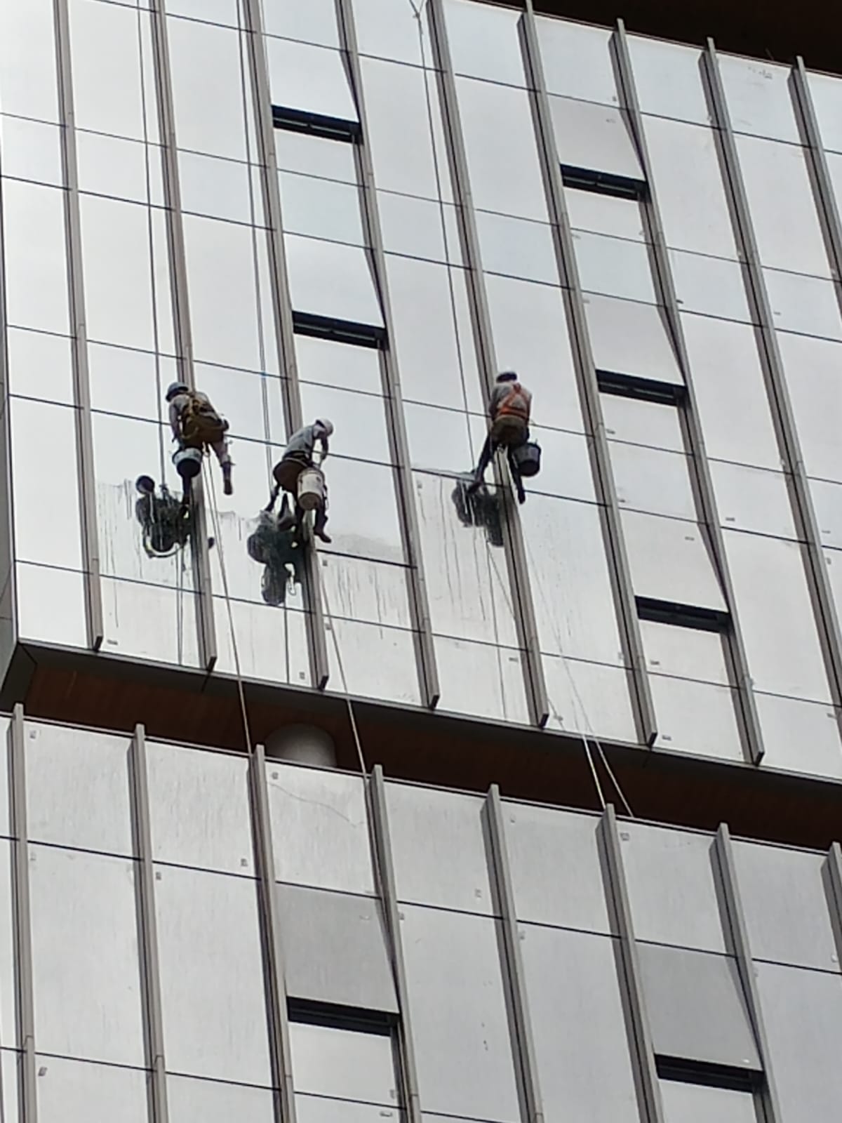 Trabalho em altura para manutenção predial externa com EPIs e normas de segurança