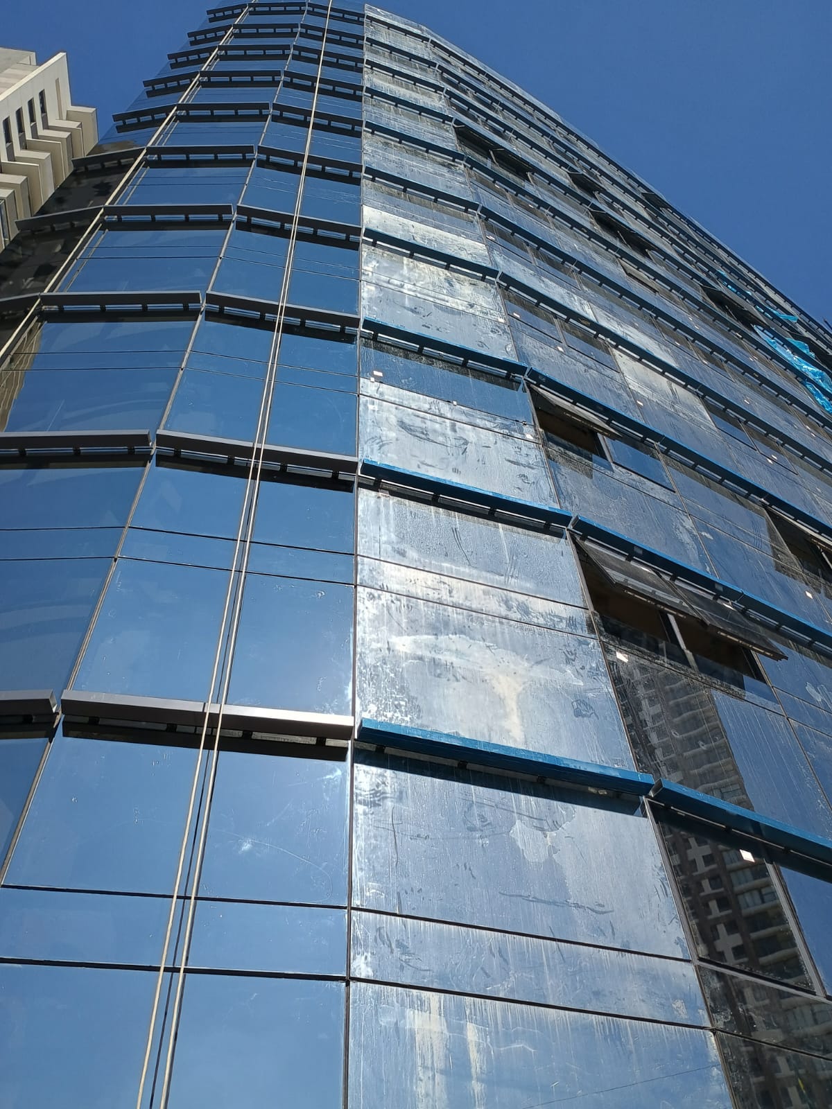 Antes e depois de limpeza de fachada de vidro — resultado da RG Serviços em Fachadas